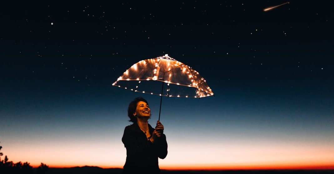 a-joyful-woman-with-a-light-up-umbrella-stands-under-a-starry-sky-capturing-a-magical-moment-17